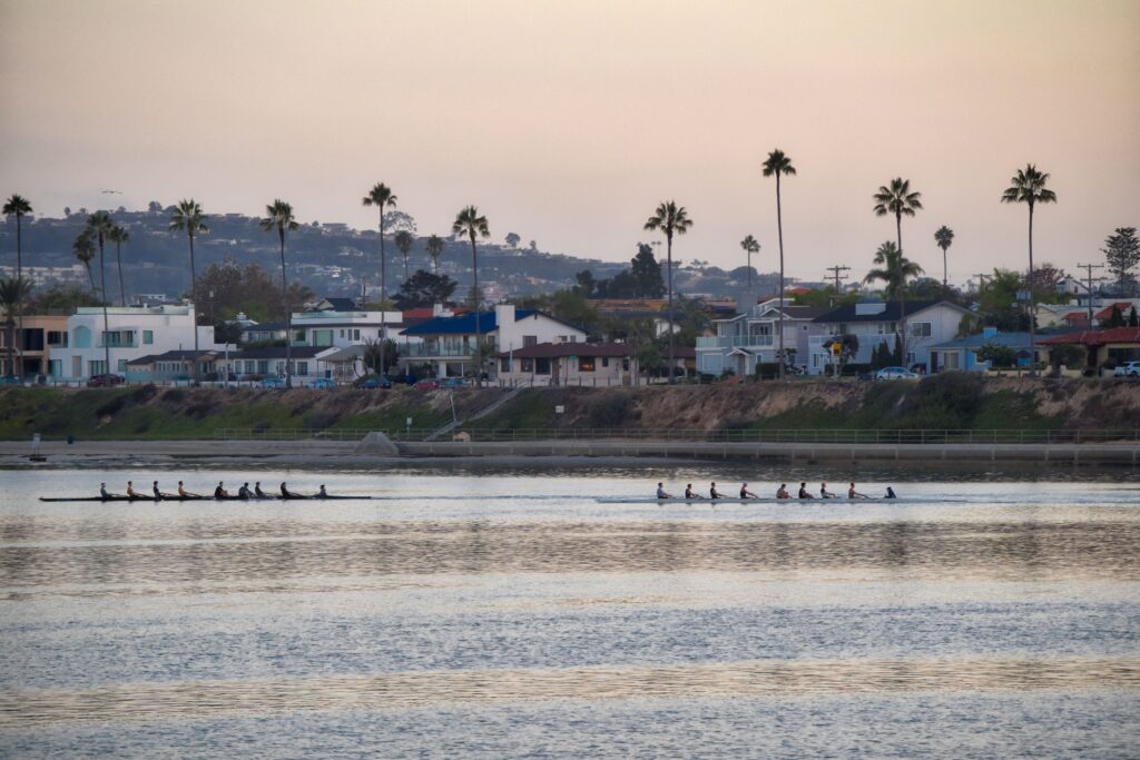 View of lakeside houses with rowers in the forefront